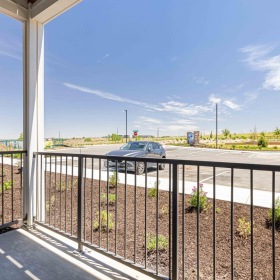 a patio with car parked in a parking lot